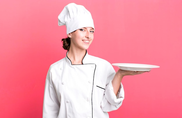 Chef de mujer rubia bonita caucásica con un concepto de plato