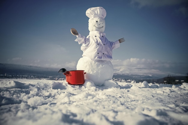 Chef de muñeco de nieve de año nuevo de nieve con olla.