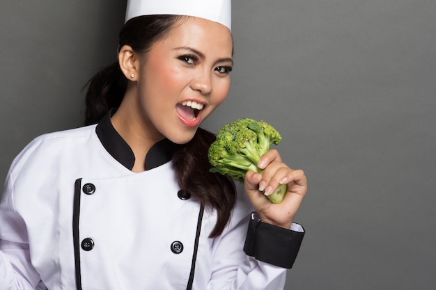 Chef muy femenina jugando con brócoli