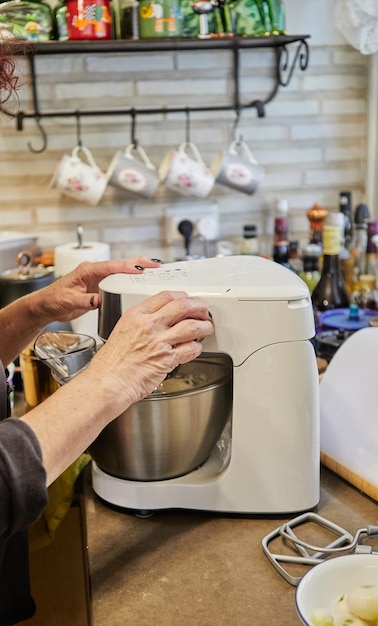 Chef na cozinha de casa com misturador de trabalho e ingredientes para cozinhar