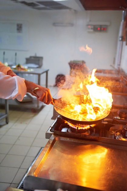 chef na cozinha do hotel preparar comida vegetal com fogo