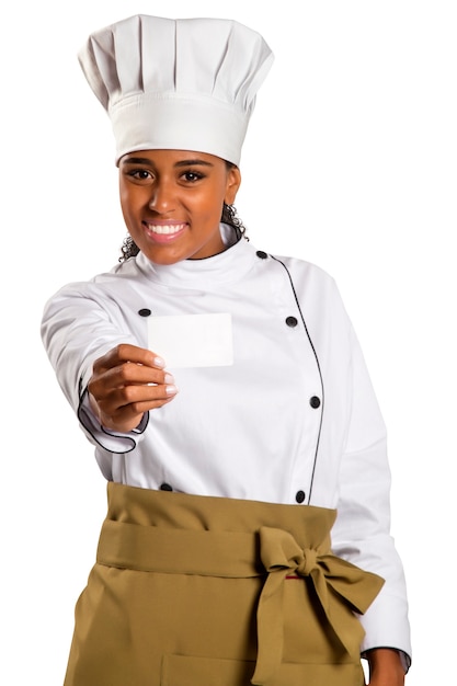 Chef, padeiro ou cozinheiro mulher mostrando o cartão de sinal em branco usando chapéu e uniforme de chefs. Cartão em branco para menu, cartão de presente, oferta, etc. Linda mulher africana / negra isolada no espaço em branco