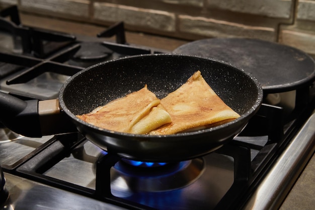 Chef panfrying crepe Suzette panquecas com conhaque e molho cítrico