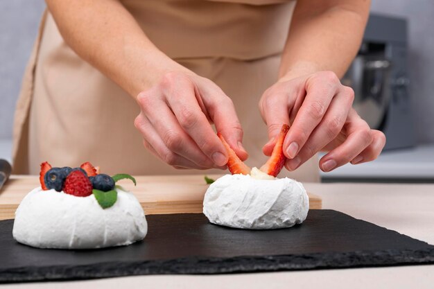 Chef pastelero prepara postre de bayas Proceso de decoración de pasteles de fresas