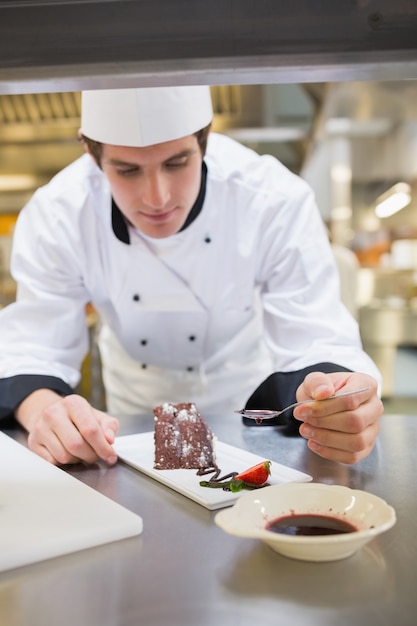 Foto chef poniendo coulis de bayas en el postre