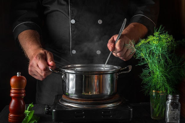 El chef prepara bolas de masa en una cacerola en la cocina del restaurante Primer plano de las manos del cocinero cocinando