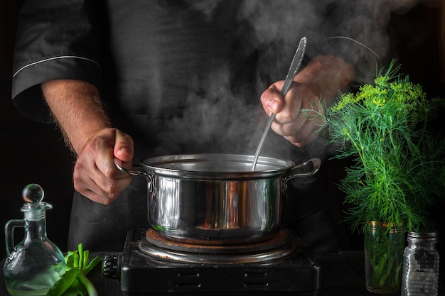 El chef prepara bolas de masa en una cacerola en la cocina del restaurante. Primer plano de las manos del cocinero mientras se cocina.