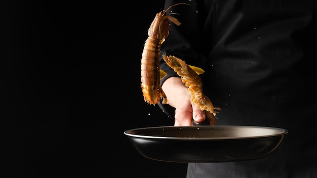 El chef prepara camarones mantis de marisco La cocina de Asia oriental se diluye en una pancarta de fotos horizontal de fondo negro