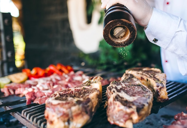 El chef prepara carne en la barbacoa.