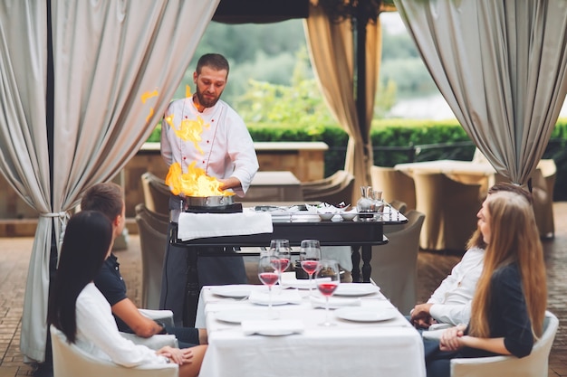 El chef prepara el foie gras ante los invitados.