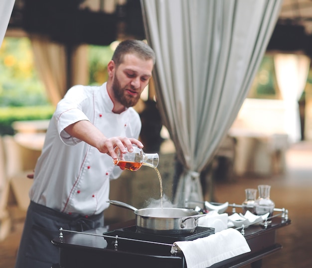 El chef prepara el foie gras ante los invitados.