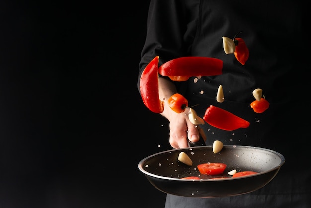 Foto chef prepara legumes assando em uma chapa em um fundo preto horizontal menu de fotos livro de receitas restaurantes comida saudável e saborosa