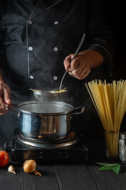 Chef prepara macarrão italiano em uma panela com legumes