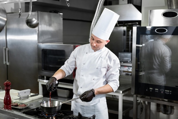 Chef prepara o molho em uma panela com vinho tinto