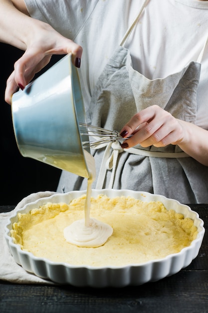 El chef prepara un pastel en una fuente para hornear.