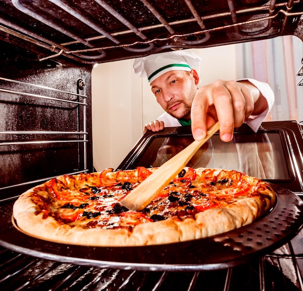 Foto chef prepara pizza no forno, vista de dentro do forno. cozinhar no forno.