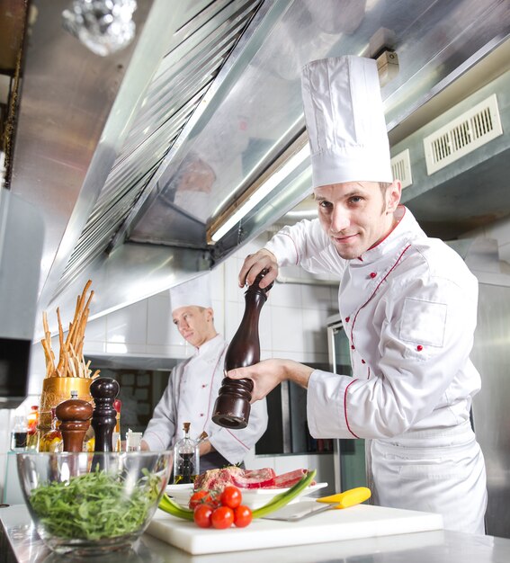 El chef prepara un plato en la cocina de restoran.