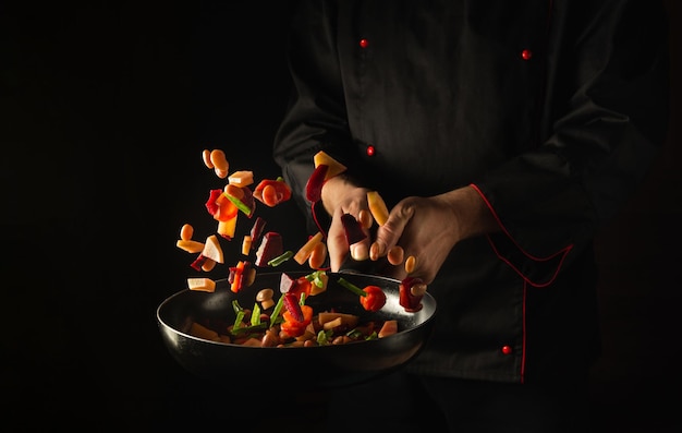 El chef prepara verduras frescas en una sartén.