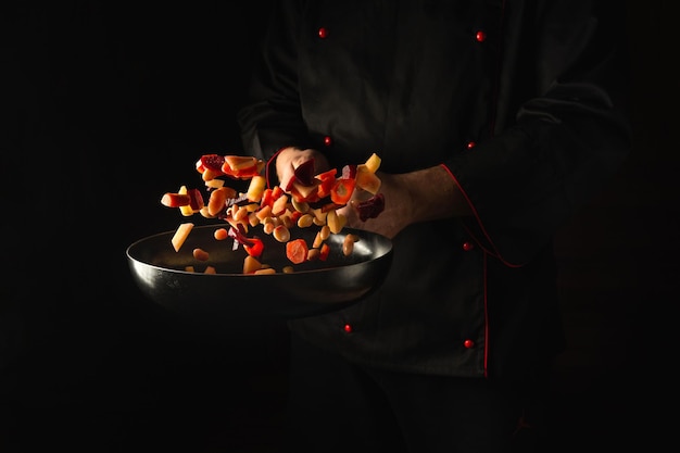 El chef prepara verduras frescas en una sartén.