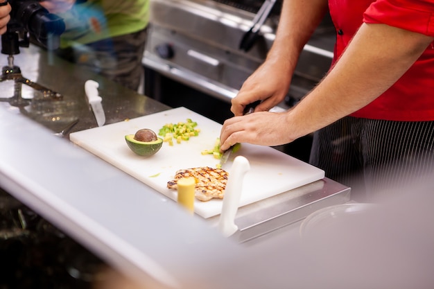 Chef preparando abacate para um delicioso salade na cozinha do restaurante