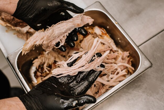 Un chef preparando carne de puerco desmenuzada. cocina tradicional americana