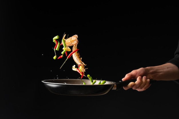 Chef preparando comida de mar camarones mantis religiosa con limón y pimiento picante y judías verdes Cocina de Asia oriental dilikates cocina vegetariana en un primer plano de foto horizontal de fondo negro