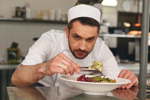 Chef preparando ensalada en la cocina moderna del restaurante Comida sabrosa y saludable