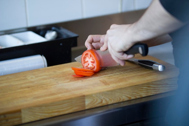 Chef preparando una ensalada en la cocina del restaurante cortando tomates, concepto de cocina y alta cocina