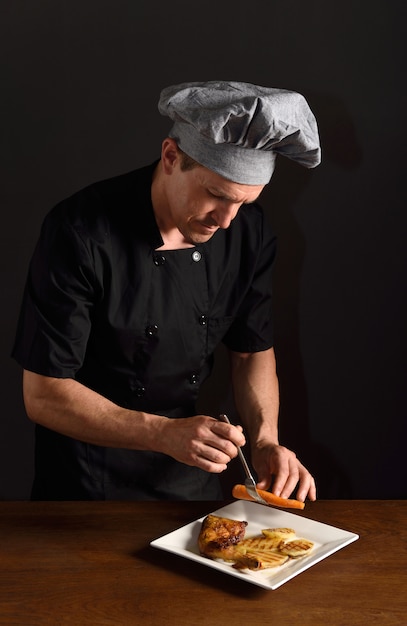 Chef preparando un plato de pollo con guarnición.