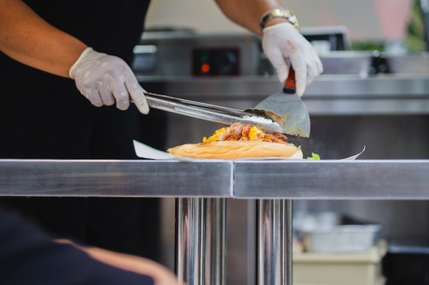 Chef preparando sándwich en food truck live cooking.