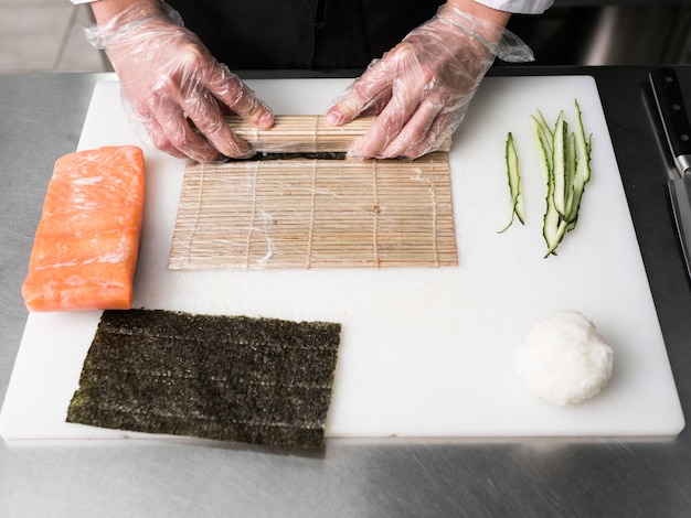 Chef preparando sushi vegetariano para clientes especiales. Comida tradicional japonesa y preferencias alimentarias modernas