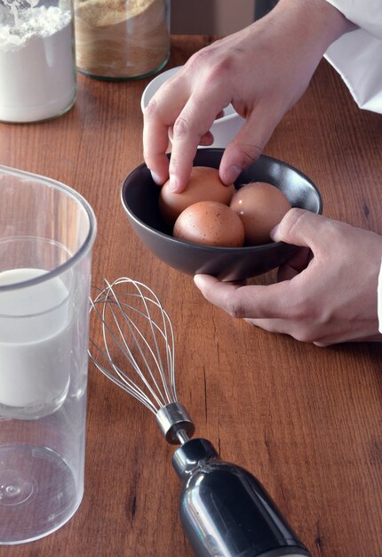 Foto chef preparando una torta con harina, leche y huevos