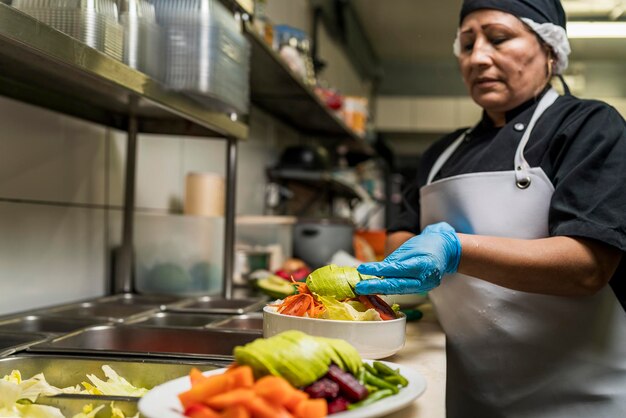 Foto chef preparando várias saladas em tigelas e pratos de cerâmica