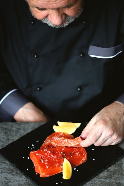El chef presenta el pepino de salmón de sushi en el tablero.