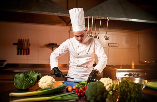 Chef profesional cocinar comida en la cocina del restaurante Jefe de cocina preparando platos con diferentes ingredientes alimentarios verduras repollo y carne