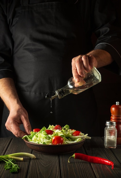 Chef profesional vierte aceite en una ensaladera en la cocina