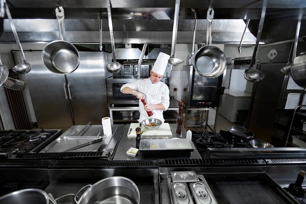 Chef profissional em uniforme branco salsa camarão