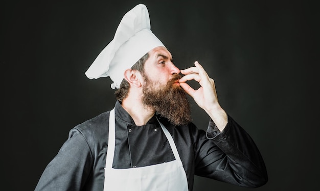 Chef profissional mostra sinal para delicioso padeiro cozinheiro masculino de uniforme com gesto de aprovação de gosto