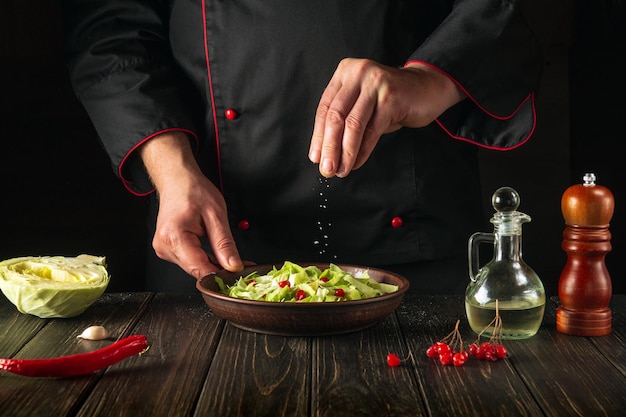 Chef profissional salga uma salada de legumes fresca Ideia de menu para um hotel Grande cozinha