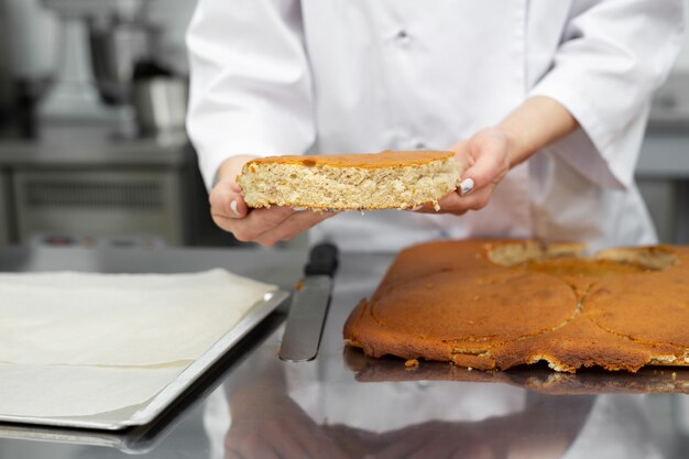 El chef de repostería corta un pastel de una galleta.