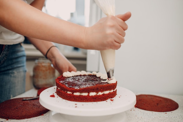 El chef de repostería hace un delicioso pastel de terciopelo rojo. Postre de cocina y decoración