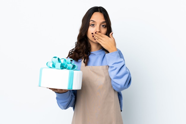 Chef de repostería sosteniendo un gran pastel aislado