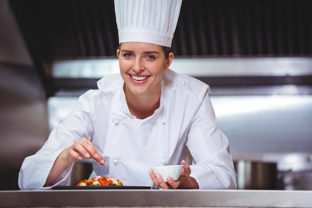 Chef rociando especias en el plato