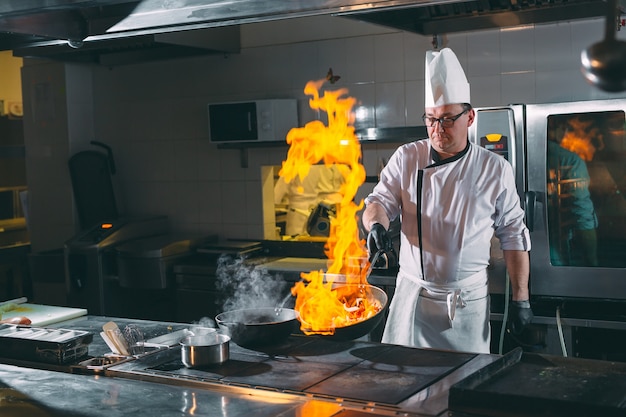 Chef rührt Gemüse im Wok.