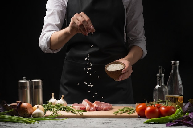 Chef salzt Steak Grillpfanne. Frisches Rindfleisch oder Schweinefleisch zubereiten.