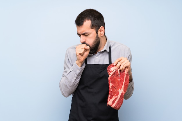 Chef segurando uma carne crua está sofrendo com tosse e se sentindo mal