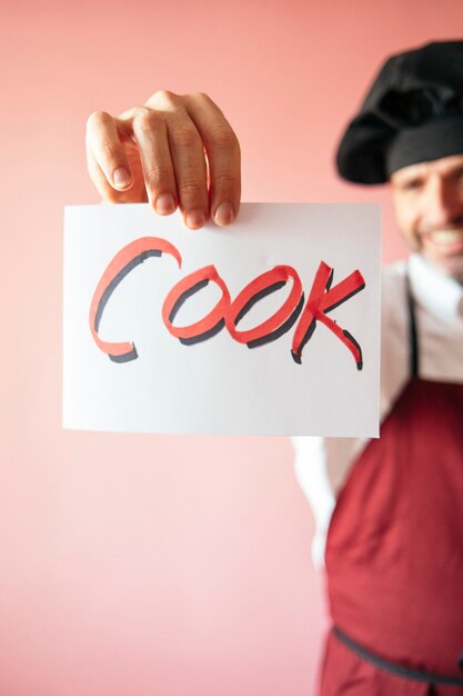 Chef, segurando uma placa que diz cozinheiro