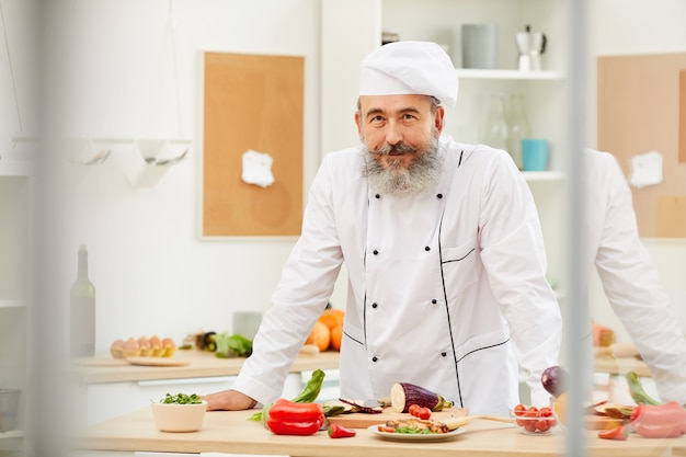 Chef Senior posando en la cocina