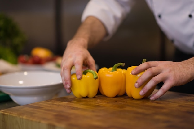 Chef sirviendo ensalada de verduras en un plato en la cocina del restaurante