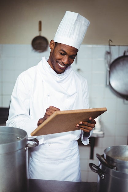 Chef sorridente fazendo anotações em uma área de transferência